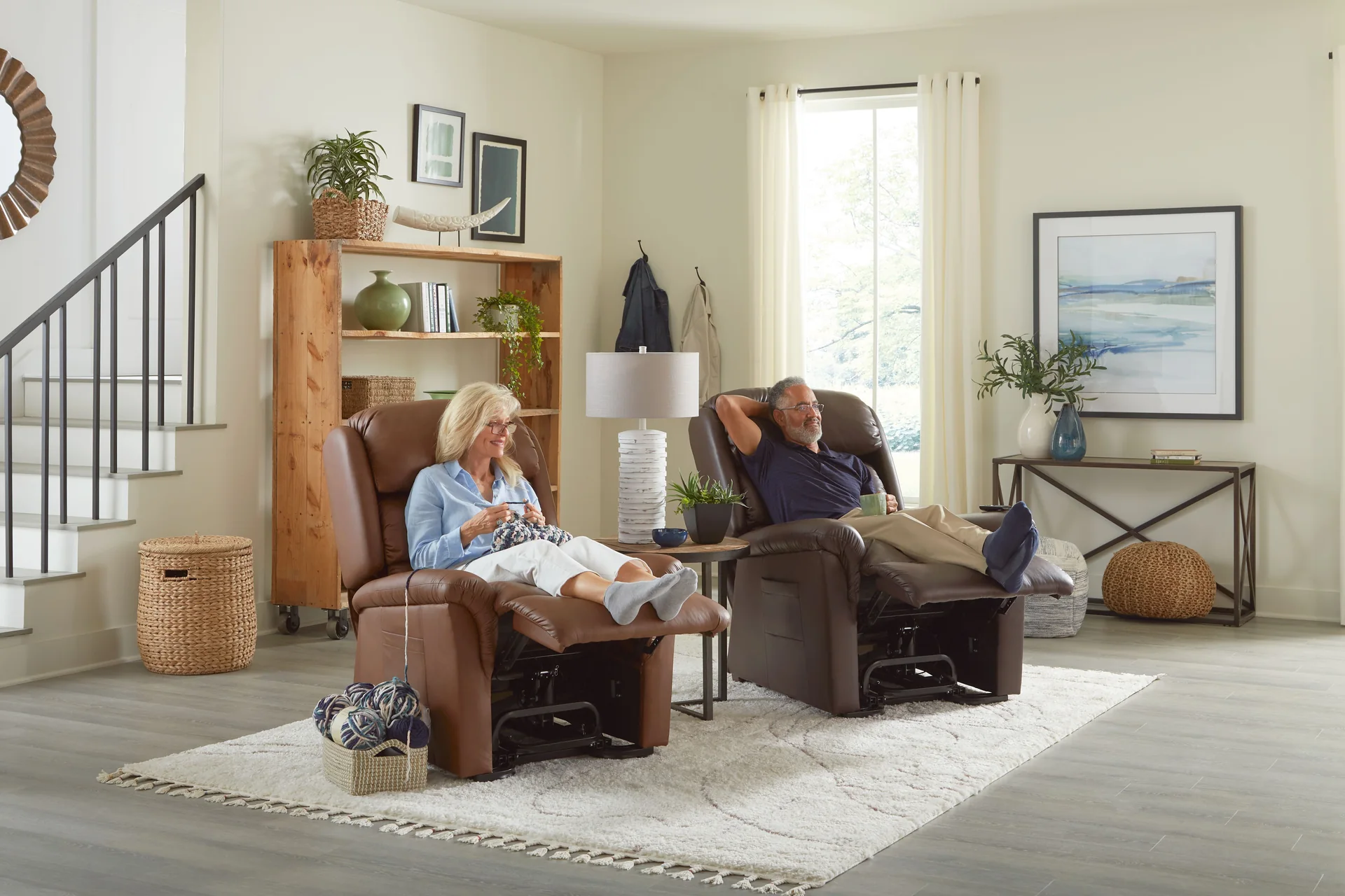 A couple relaxing side by side in two UltraComfort Polaris power lift recliners in a bright living room