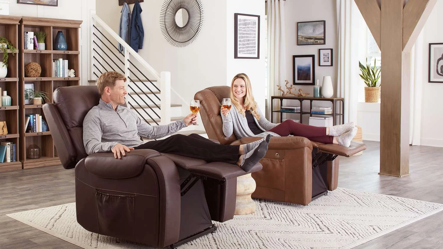 A couple relaxing in two UltraCozy power recliners in a bright living room